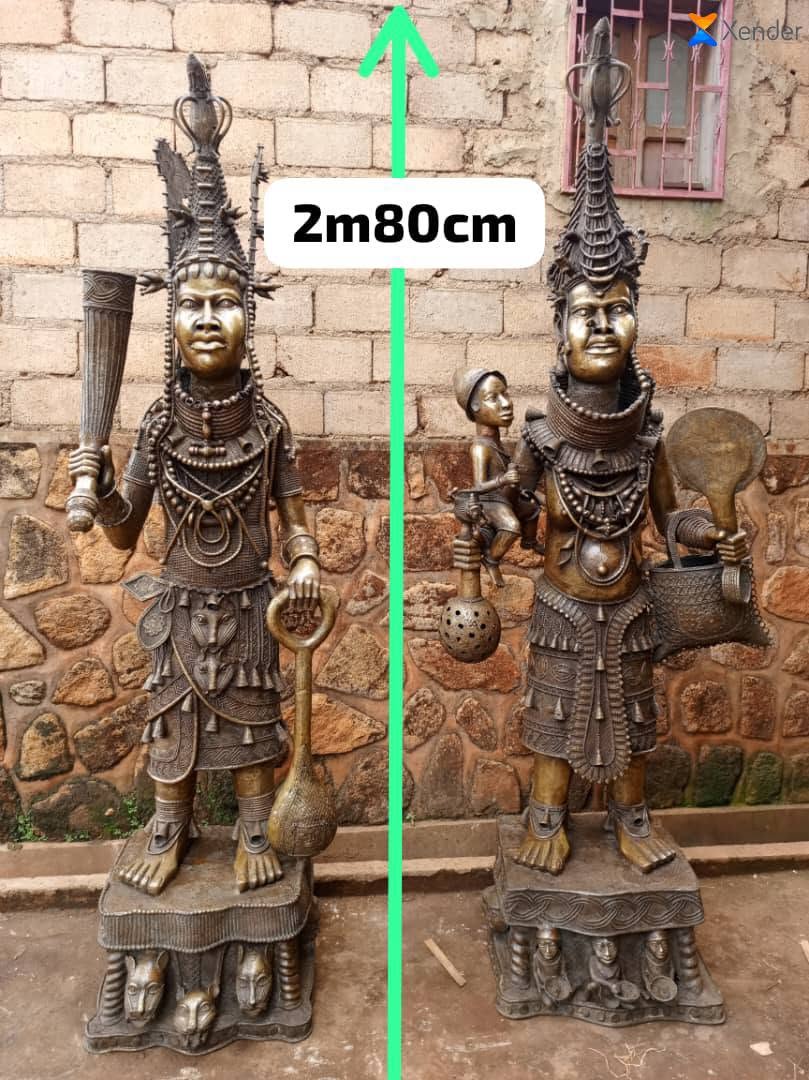 Deux statues royales en bronze de 2 m 80 devant un mur de briques