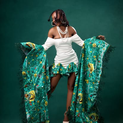 Mannequin en robe blanche à volants avec étole verte brodée à franges