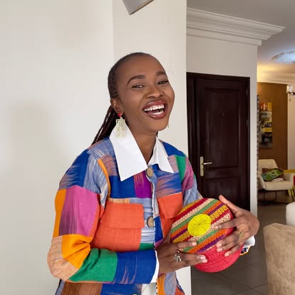 Femme souriante en veste patchwork multicolore tenant un panier tressé