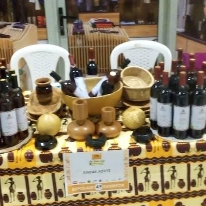 Table de dégustation Kindak avec bouteilles, verres en bois et paniers tressés