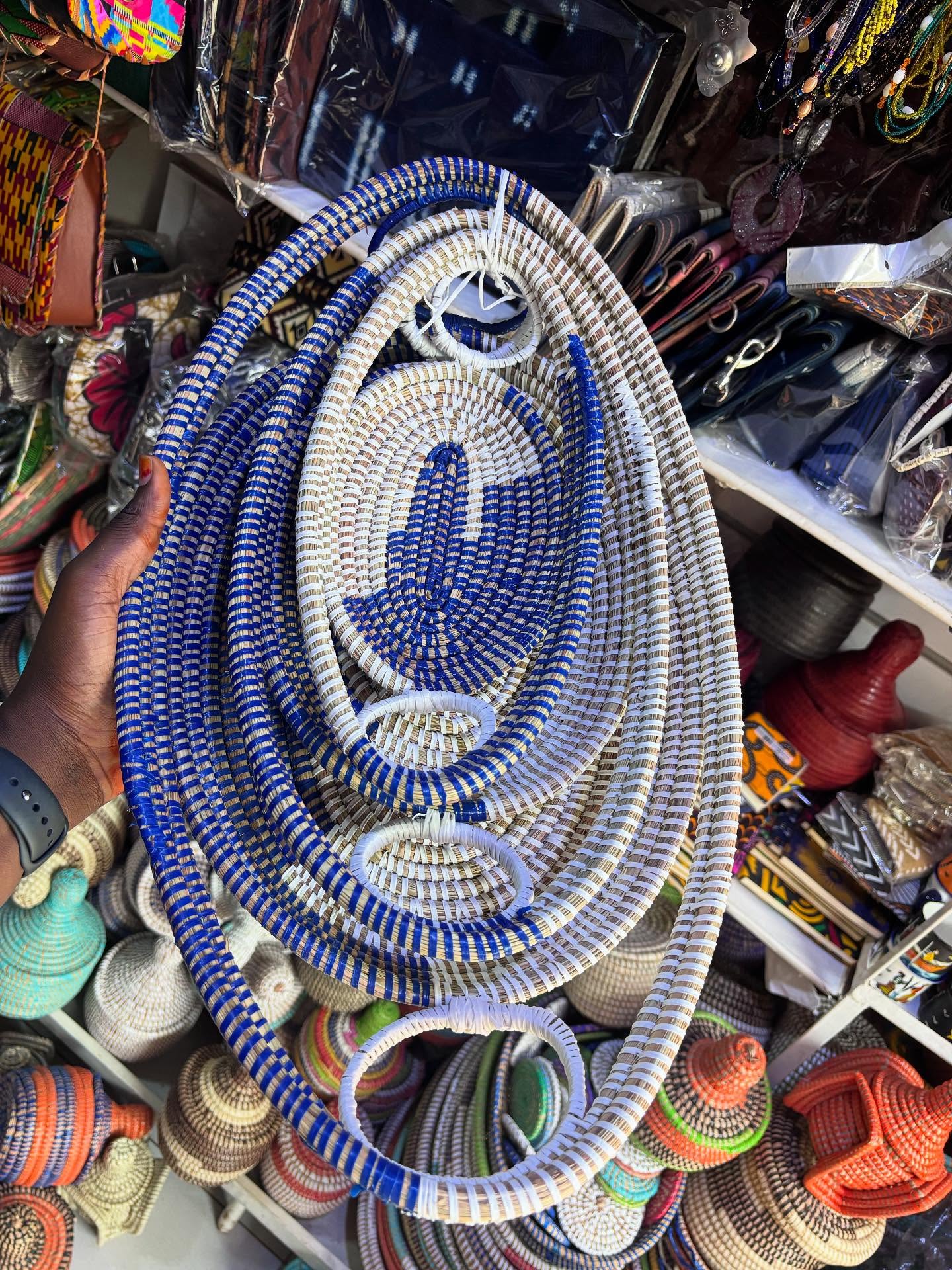 Grande corbeille ovale tressée bleu et blanc tenue en main dans la boutique