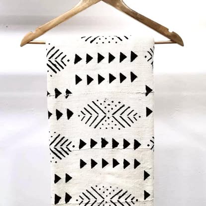 Pièce de tissu bogolan écru à motifs triangles noirs sur un cintre