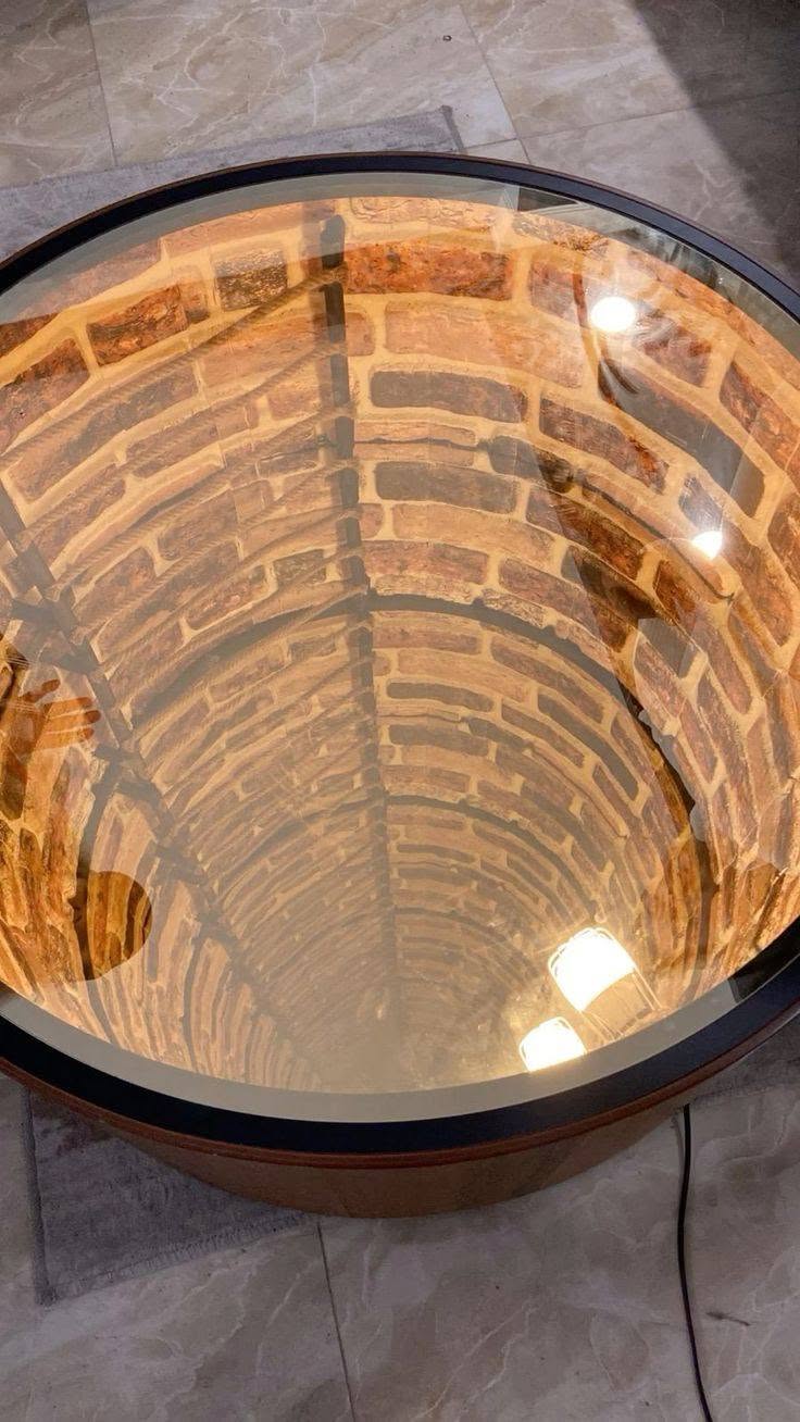 Détail du puits de briques éclairé en profondeur sous le plateau en verre