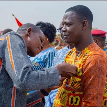 Habillage d'un client en tenue de cérémonie orange à motifs