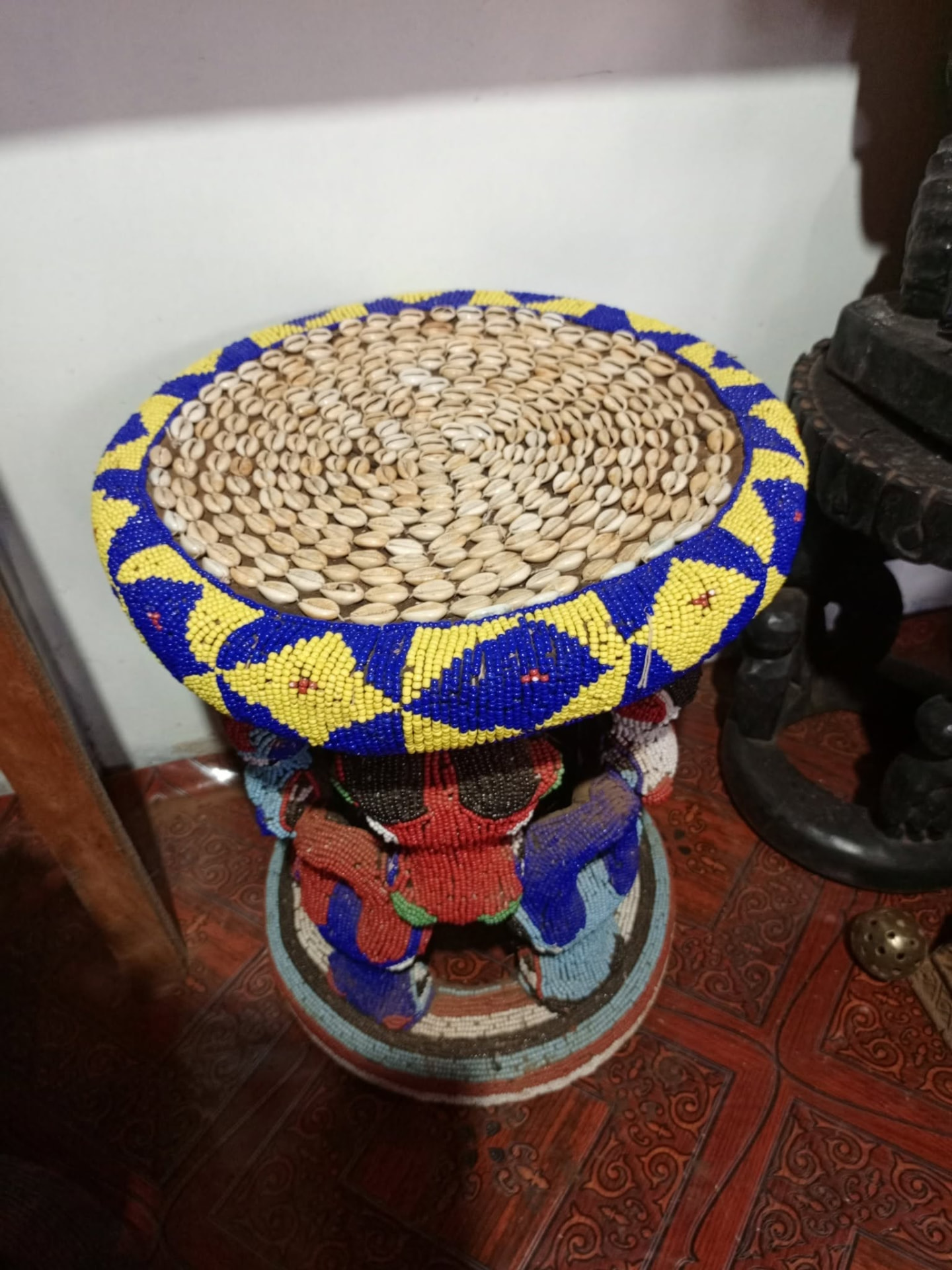 Tabouret cérémoniel recouvert de cauris et de perles bleues et jaunes