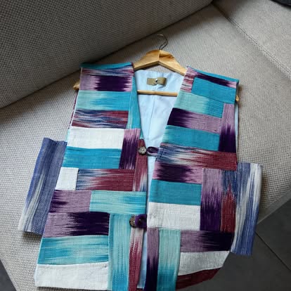 Gilet patchwork turquoise, violet et bordeaux sur un cintre