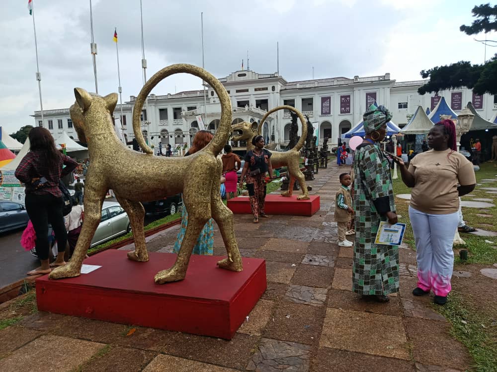 Deux léopards en bronze doré alignés dans l'allée du salon SIARC 2026 à Yaoundé