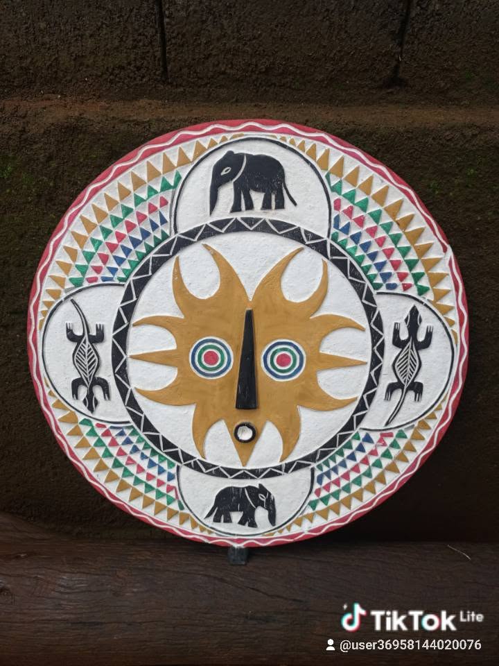 Bouclier rond en bois peint de motifs éléphants, lézards et masque solaire