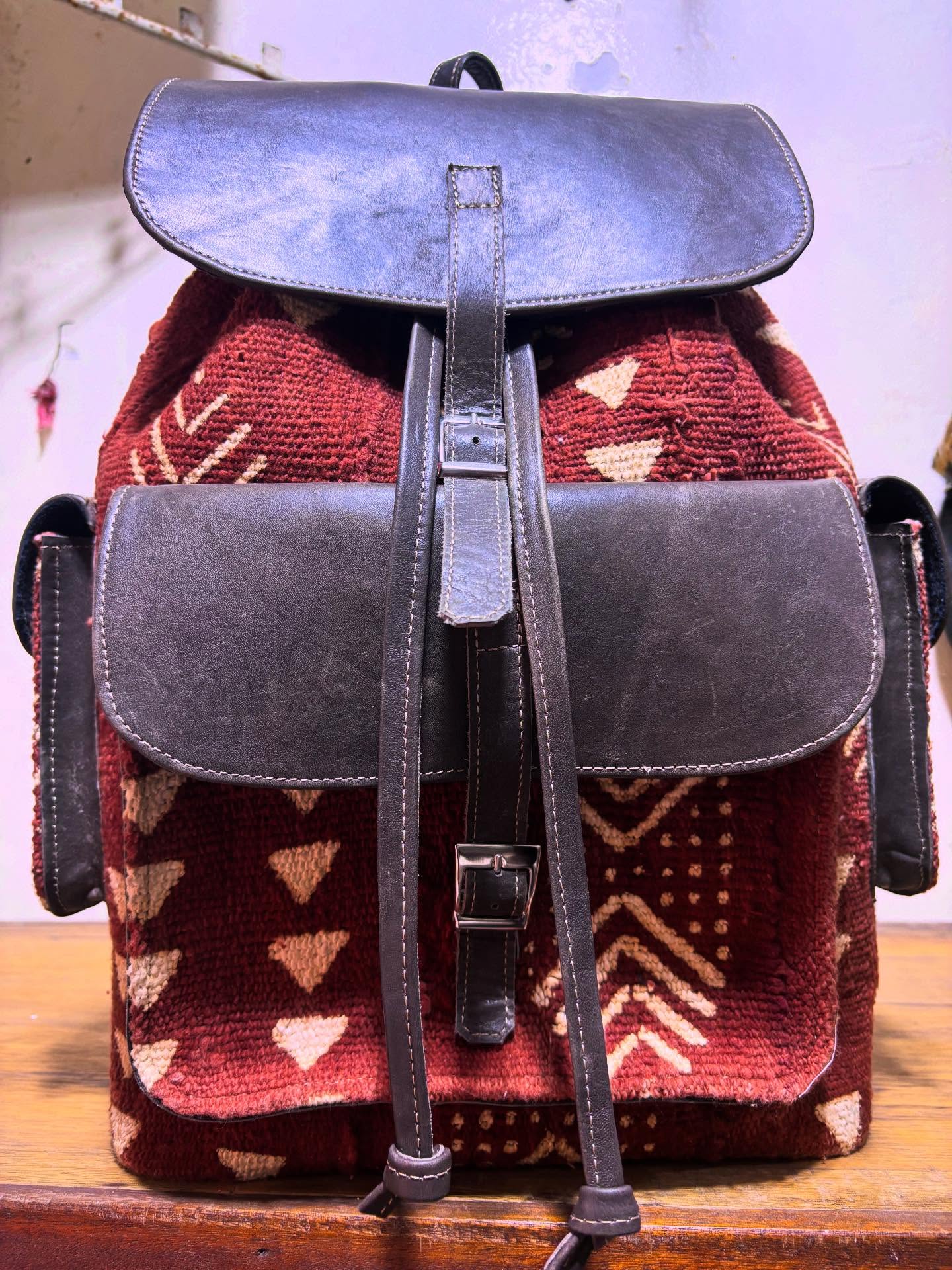 Gros plan sur un sac à dos en bogolan rouge et cuir noir