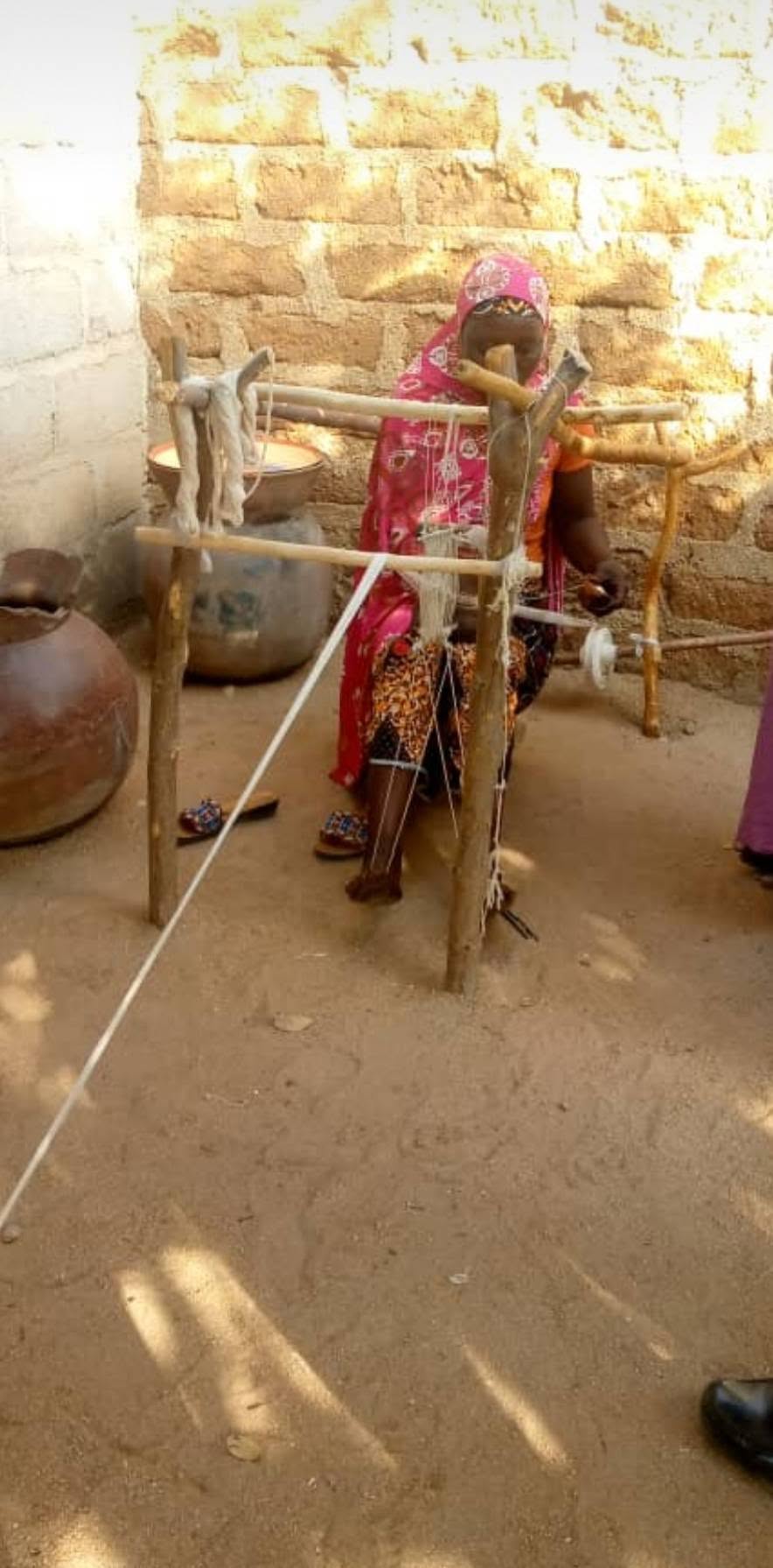 Artisane de Garoua filant du coton sur un métier traditionnel en bois