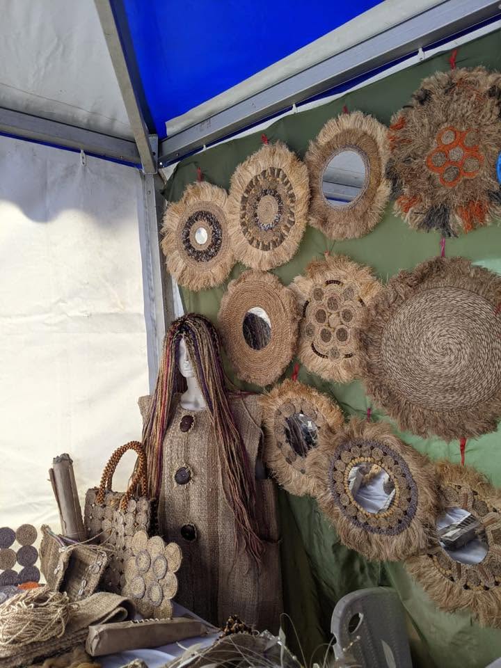 Stand couvert de miroirs ronds et décorations murales en fibres naturelles