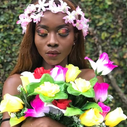 Portrait d'une mannequin avec couronne de fleurs et bouquet coloré