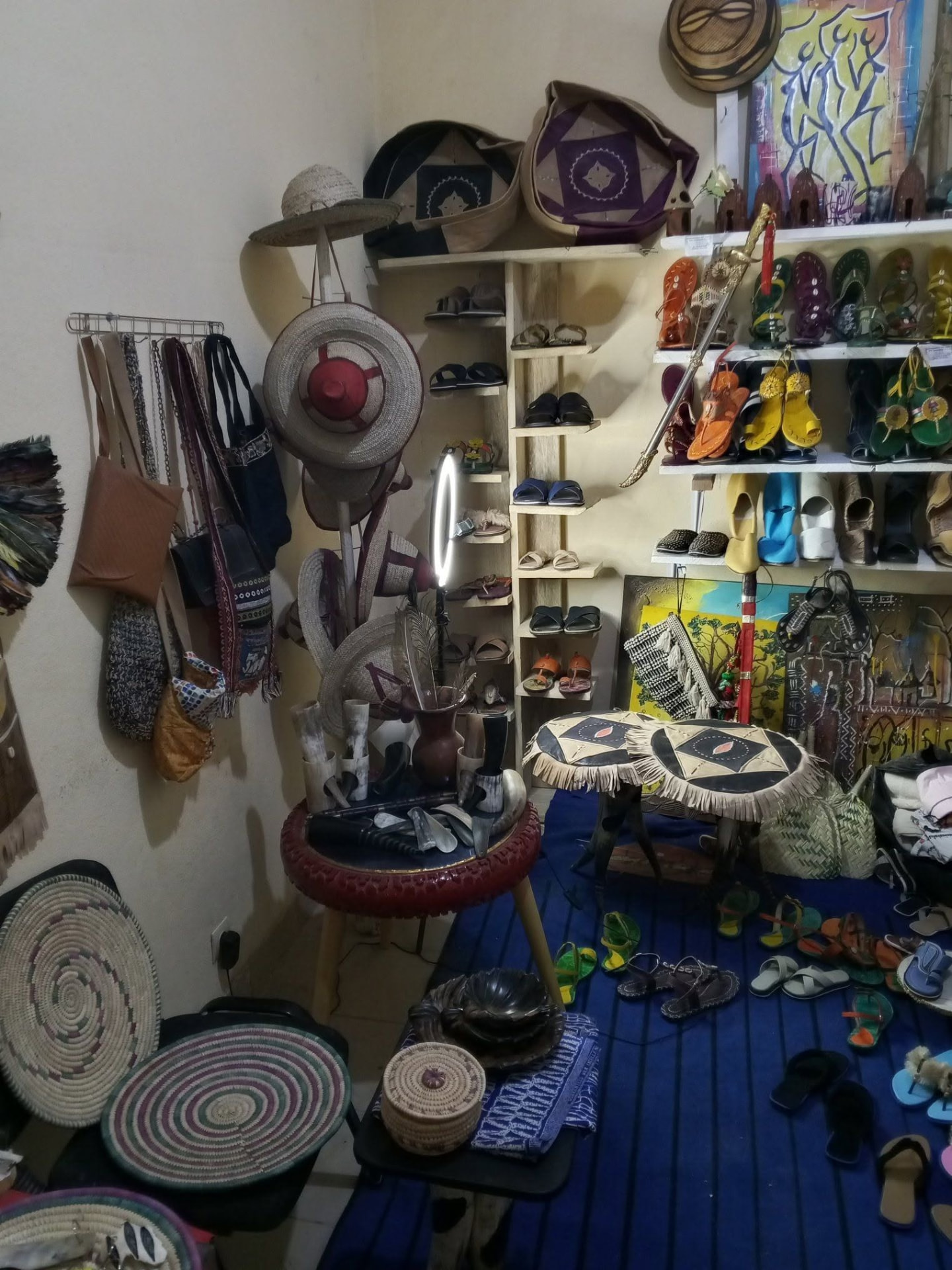 Intérieur de l'atelier-boutique du Village : chapeaux, sacs, sandales, babouches et vannerie