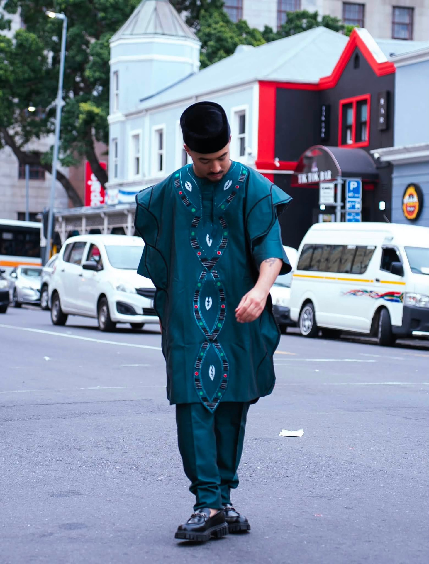 Détail des broderies géométriques d'un agbada vert sapin