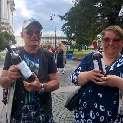 Deux visiteurs présentant des bouteilles Kindak lors d'un voyage en Russie