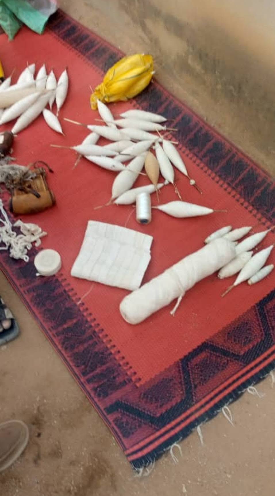 Fuseaux, coton et outils traditionnels de filage disposés sur une natte