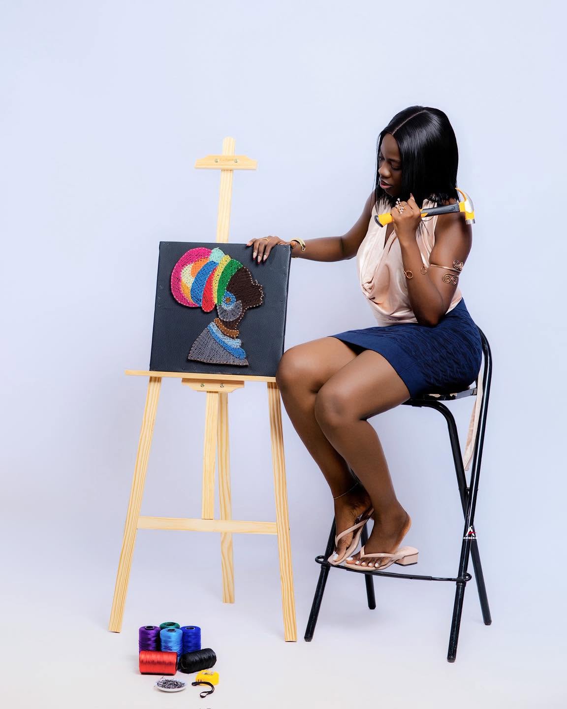 L'artisane assise avec un marteau à côté d'un portrait de femme au turban coloré en fils tendus